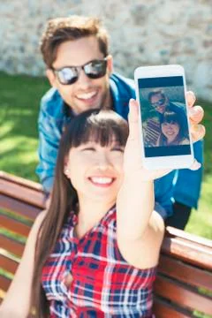 Young happy couple using smartphone in the park Stock Photos