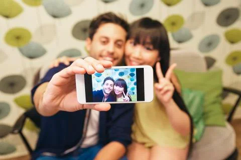 Young happy couple using smartphone in the bar Stock Photos