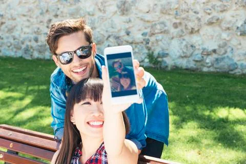 Young happy couple using smartphone in the park Stock Photos