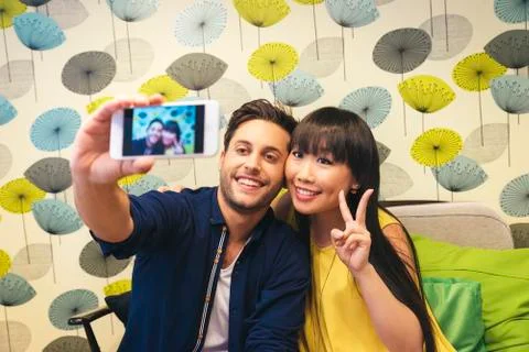 Young happy couple using smartphone in the bar Stock Photos