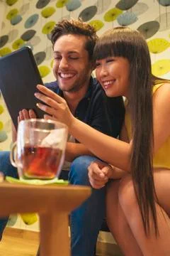 Young happy couple using tablet in the bar. Stock Photos