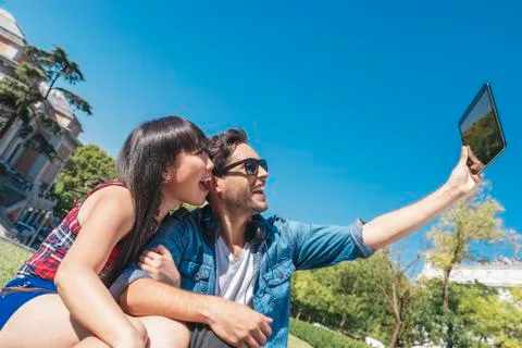 Young happy couple using tablet in the park Stock Photos