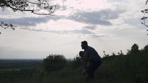 Young happy dad on the mountain throws up a 2 year old daughter on the Stock Footage 131252950