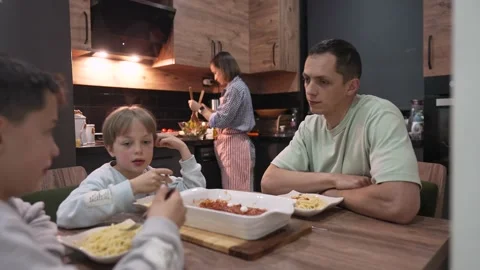 Young happy family talking while having dinner at home table Stock Footage 172214569