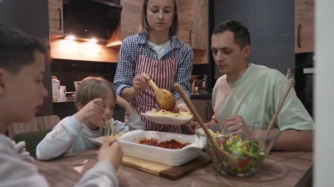 Young happy family talking while having dinner at home table Stock-Footage 183329407