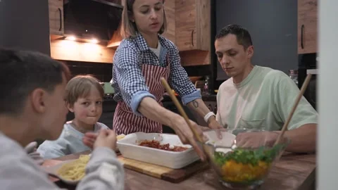 Young happy family talking while having dinner at home table Stockbeeldmateriaal 192228878
