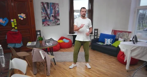Young happy freelancer guy dancing in apartment Stock Footage 99321867