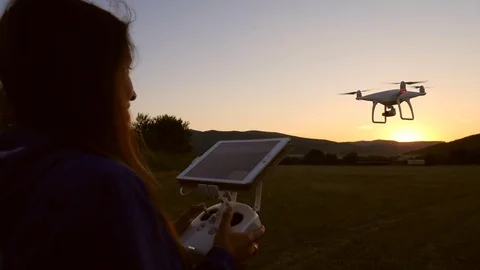 Young Happy Girl With Remote Control Controls the Quadcopter Drone on Field Stock Footage