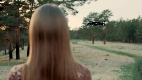 Young Happy Girl With Remote Control Controls the Quadcopter Drone on Field Stock Footage 109263653