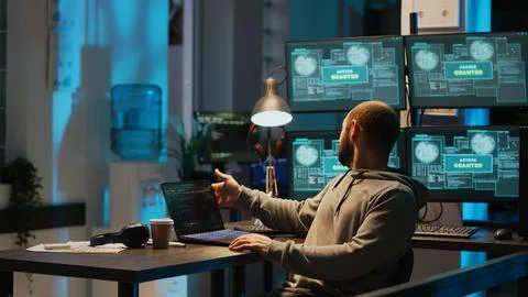 Young happy hacker celebrating coding achievement at night 写真素材