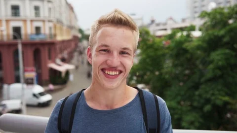 Young happy handsome guy smiling at city street Stock Footage 92360375