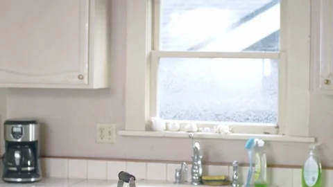 Young happy hispanic man slides into bright kitchen for morning tea by window Stock Footage 84478922