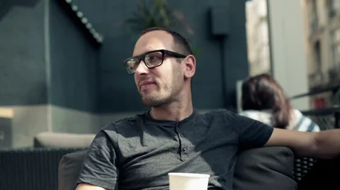 Young happy man drinking coffee and relaxing in cafe HD Stock Footage 31744269