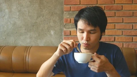 Young happy man drinking coffee and relaxing in café Stock Footage 77183676