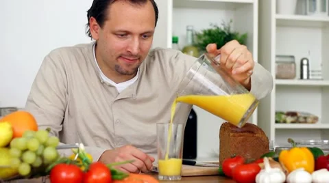 Young happy man drinking fresh healthy juice in the kitchen HD Stock Footage 8988935