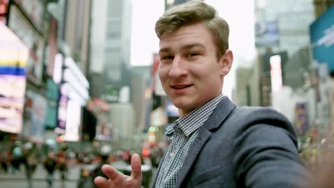 Young happy man is holding a camera in front of him and pointing on something in Stock Footage 79593985