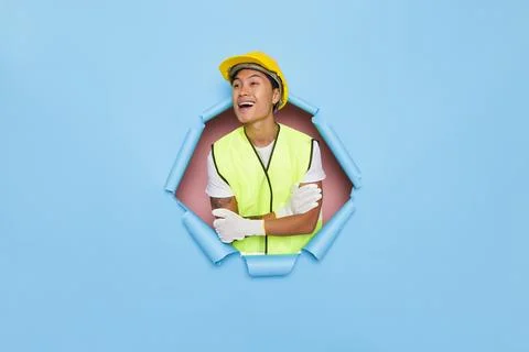 Young happy man model posing in yellow hard hat, yellow vest and white gloves Stock Photos