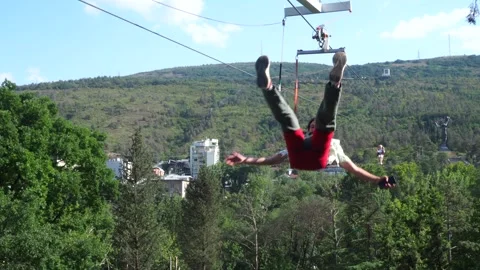 Young happy man riding a zip line Stock Footage 246565719