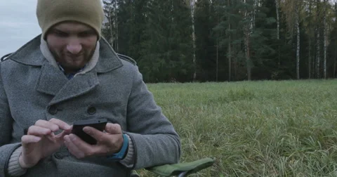 Young happy man talking on mobile phone in the park Video stock 63359459