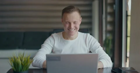 Young happy man talking via videoconference on laptop, greeting, waving his hand Stock Footage 197603658