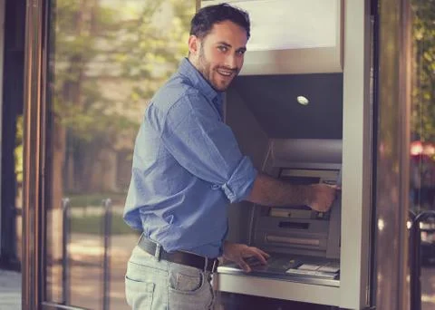 Young happy man using ATM Stock Photos