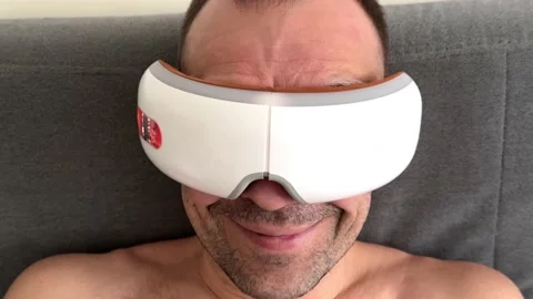 Young happy man using face and eye area massager. Stock Footage 239912711