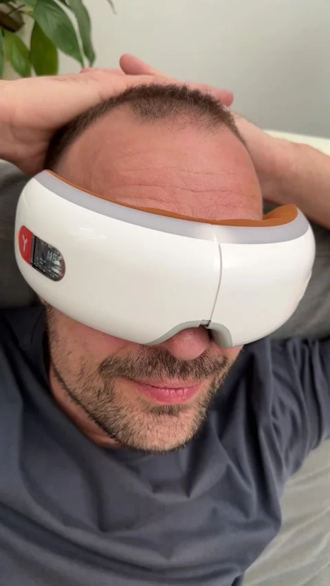 Young happy man using facial and eye massager. Stock Footage 239910859
