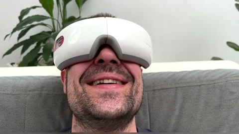 Young happy man using facial and eye massager. Stock Footage 239912662