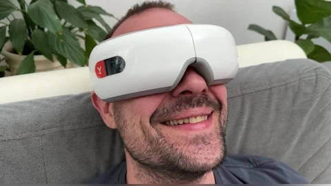 Young happy man using facial and eye massager. Stock Footage 239912685