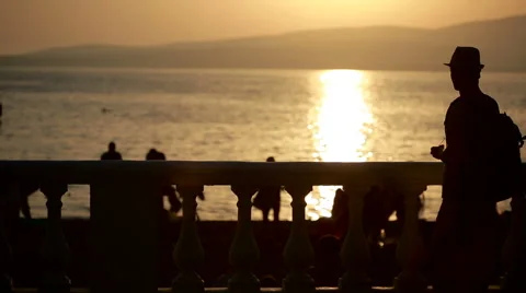 Young happy man using smartphone by the sea. tourist walks along the promenade Stock Footage 65430397