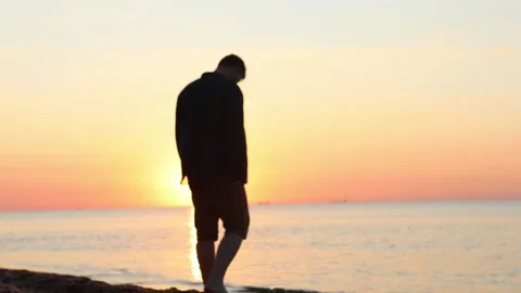 Young happy man walking by sandy sea beach on sunrise Stock Footage 147675789