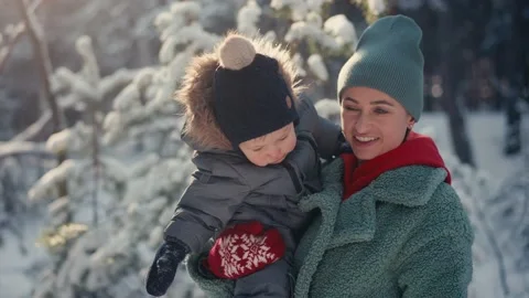 Young happy mother having fun and playing with toddler son in snowy forest in Stockbeeldmateriaal 167995471