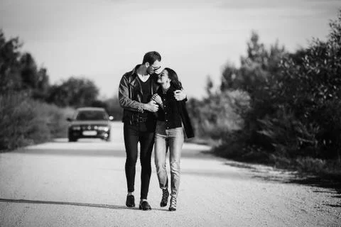 Young happy romantic couple walking along road Stock Photos