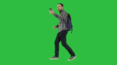 Young happy smiling man with backpack recording vlog blog with his phone on a Stock-Footage 100057695