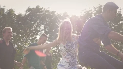 Young happy students walking and riding a bike in park at sunset. Видео 77237065