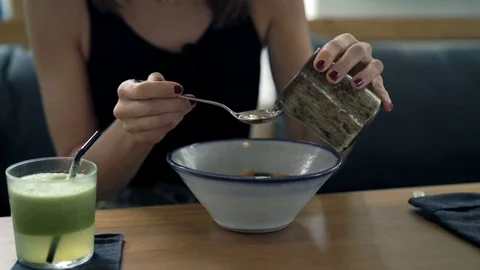 Young happy woman adding sauce to the salad in cafe, 4K Stock Footage 70791108