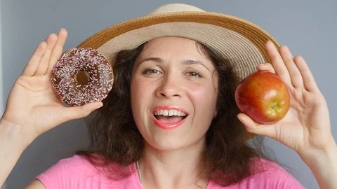 Young happy woman with apple and donut Stock Footage