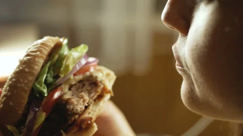 Young happy woman eating tasty fast food burger, close-up Stock Footage