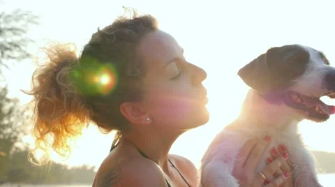 Young Happy Woman Holding Cute Puppy Dog on the Beach. Slow Motion Stock Footage
