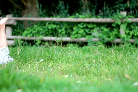 Young happy woman lying on the grass, dolly shot Stock Footage