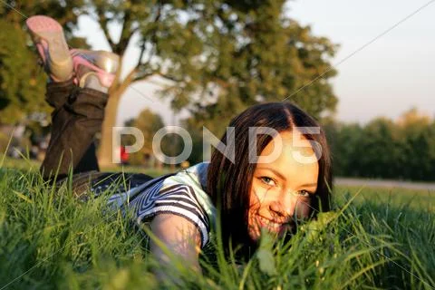 Young happy woman lying on the grass Stock Photos