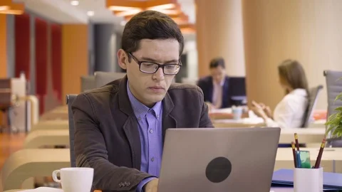 Young hardworking woman works on laptop very focused sitting in co working Stock Footage