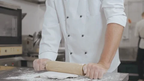 Young head chef rolling dough for bakery in industrial kitchen Stock Footage 125049707