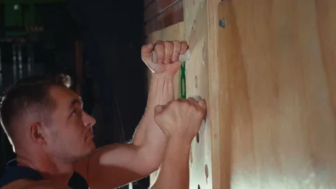 Young healthy man doing crossfitt peg board ascent exercise slow motion Stock Footage 131222839