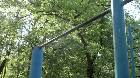 Young healthy man exercising pull ups on a horizontal bar in the park Stock Footage 130268593
