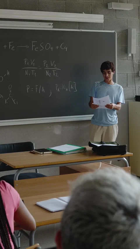 Young high school student boy giving a presentation in front of his classmates Stock Footage 310779260