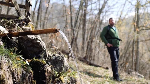 Young hiker drinking the mountain spring water Stock Footage 88303586