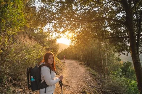 Young hiker, looking at the camera, watching the sunset on the mountain. concept Stock Photos