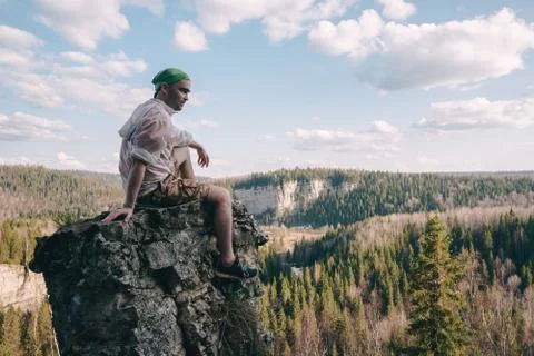 Young hiker looking down from a top of a mountain Stock Photos