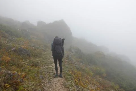 Young hiker man walking in mist fog mountain top, Langtang, Nepal, 2019 Stock Photos